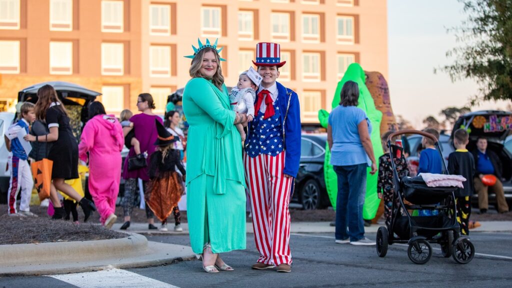 Picture of two women in costumes holding a baby