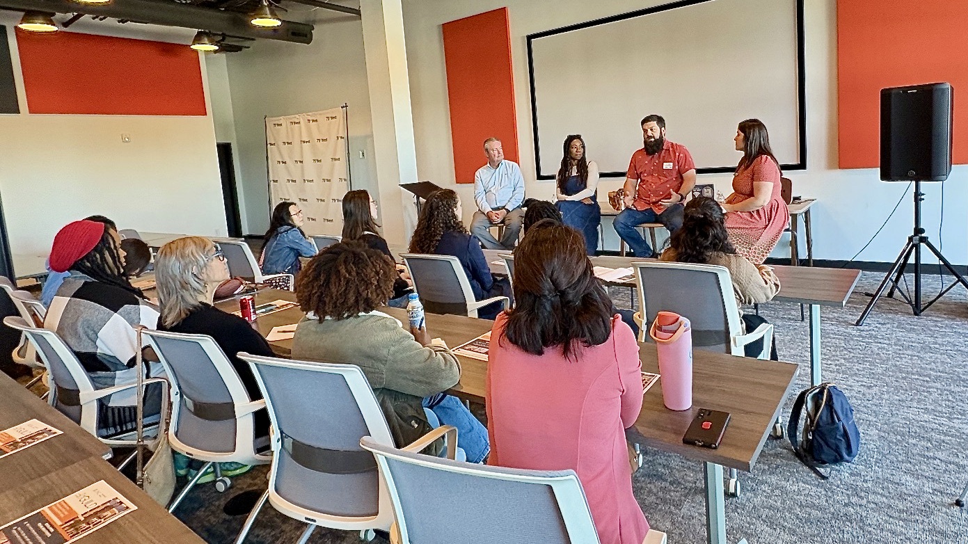 4 speakers on a panel in front of an audience at 79West in Pittsboro