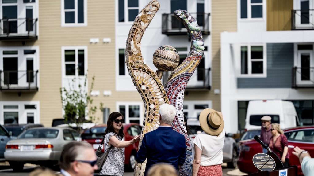 People interacting with Leaning In Sculpture at MOSAIC.