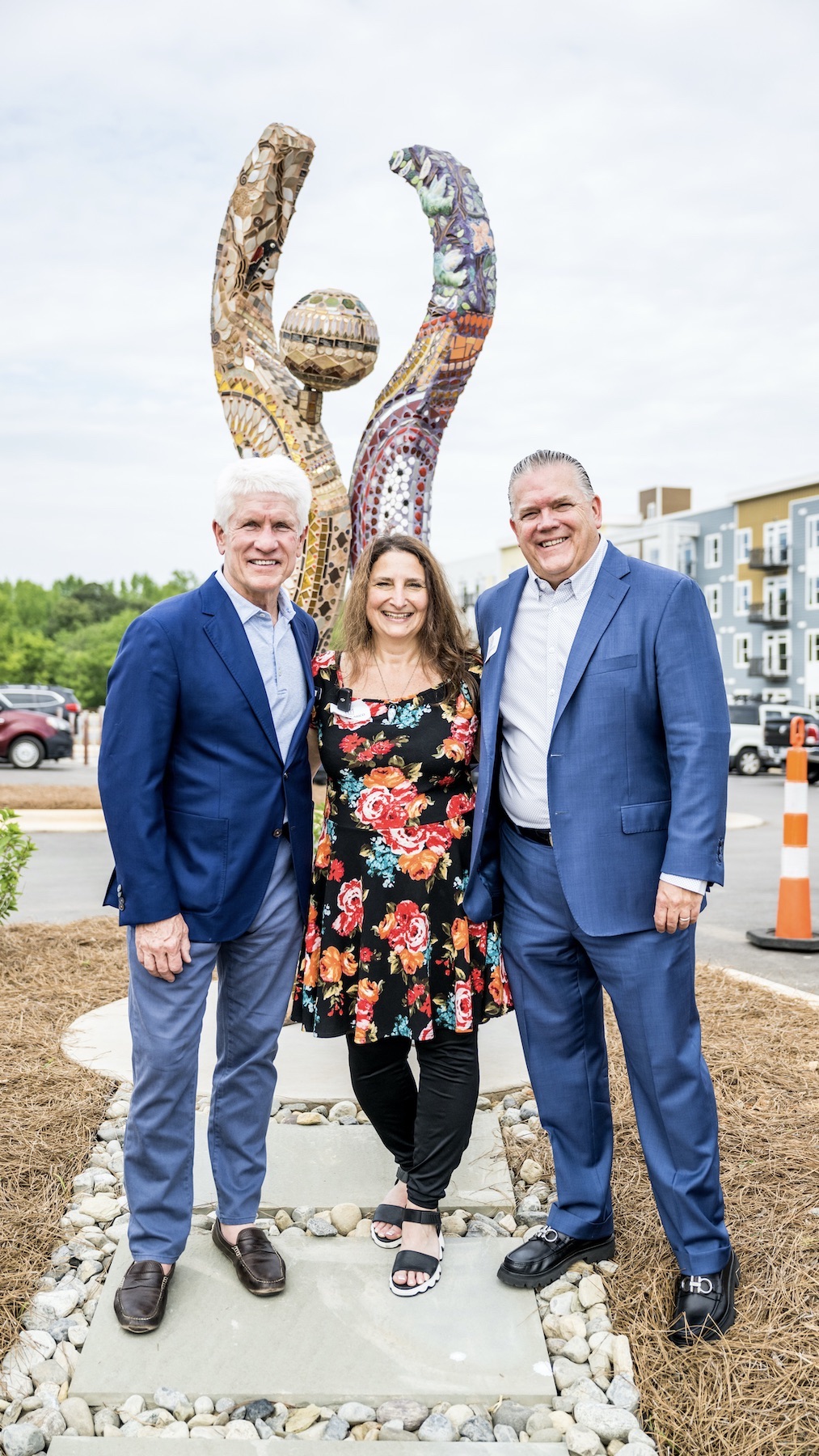 The presenters of the Leaning In dedication ceremony pose in front of the sculpture.