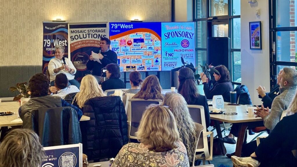 A good-sized crowd listening to a man and woman speak in an interview
