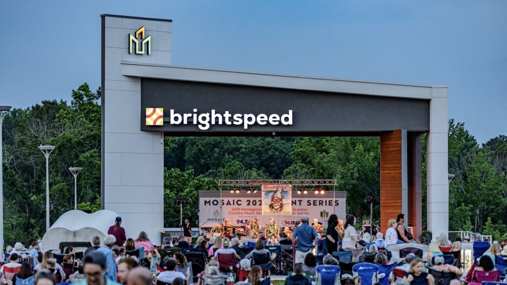 Picture of large stage with people at an outdoor concert