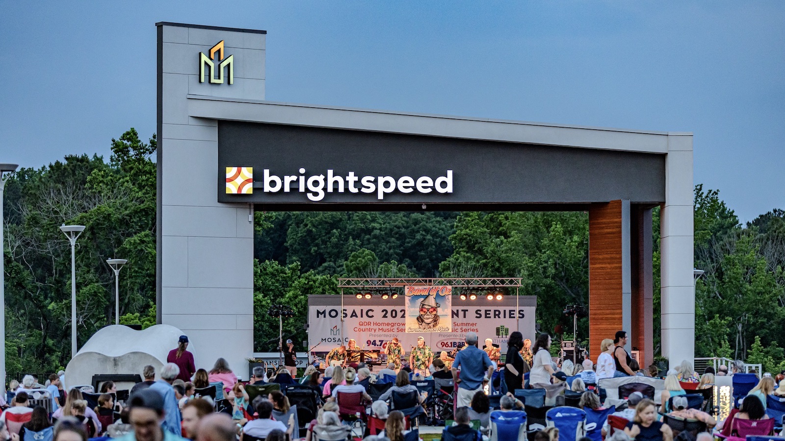 Picture of large stage with people at an outdoor concert