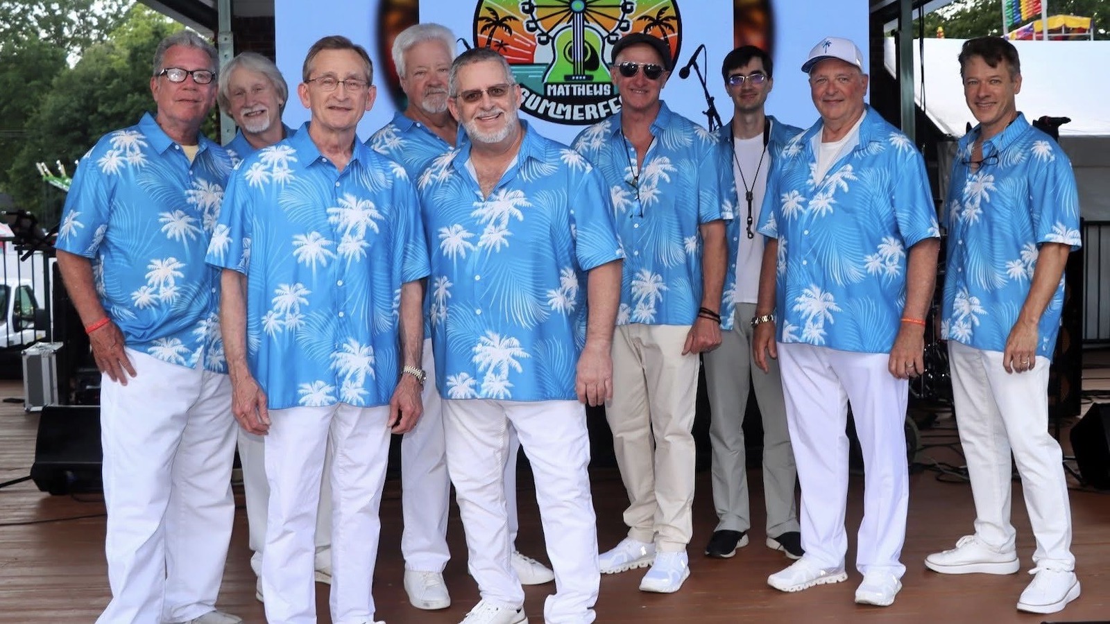 Members of the band The Catalinas pose in floral shirts on stage after a performance.