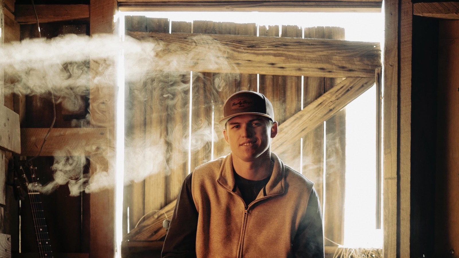 Dalton Davis sitting on a bar stool in a barn setting.