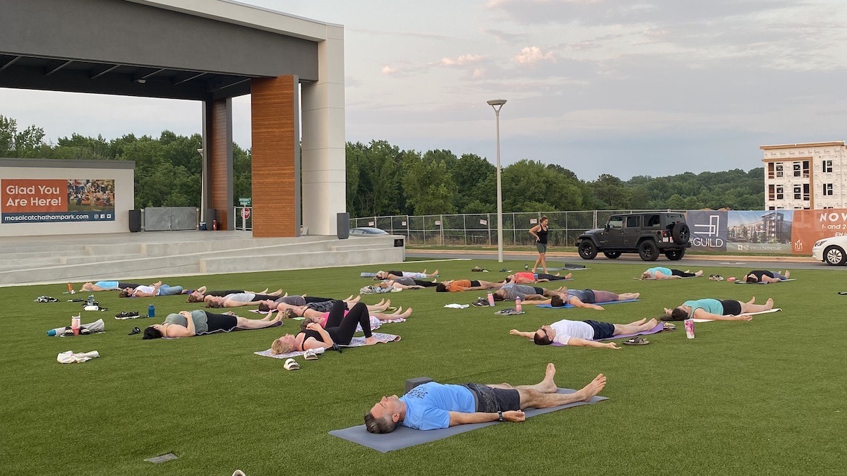 People participating in yoga on the lawn at MOSAIC.