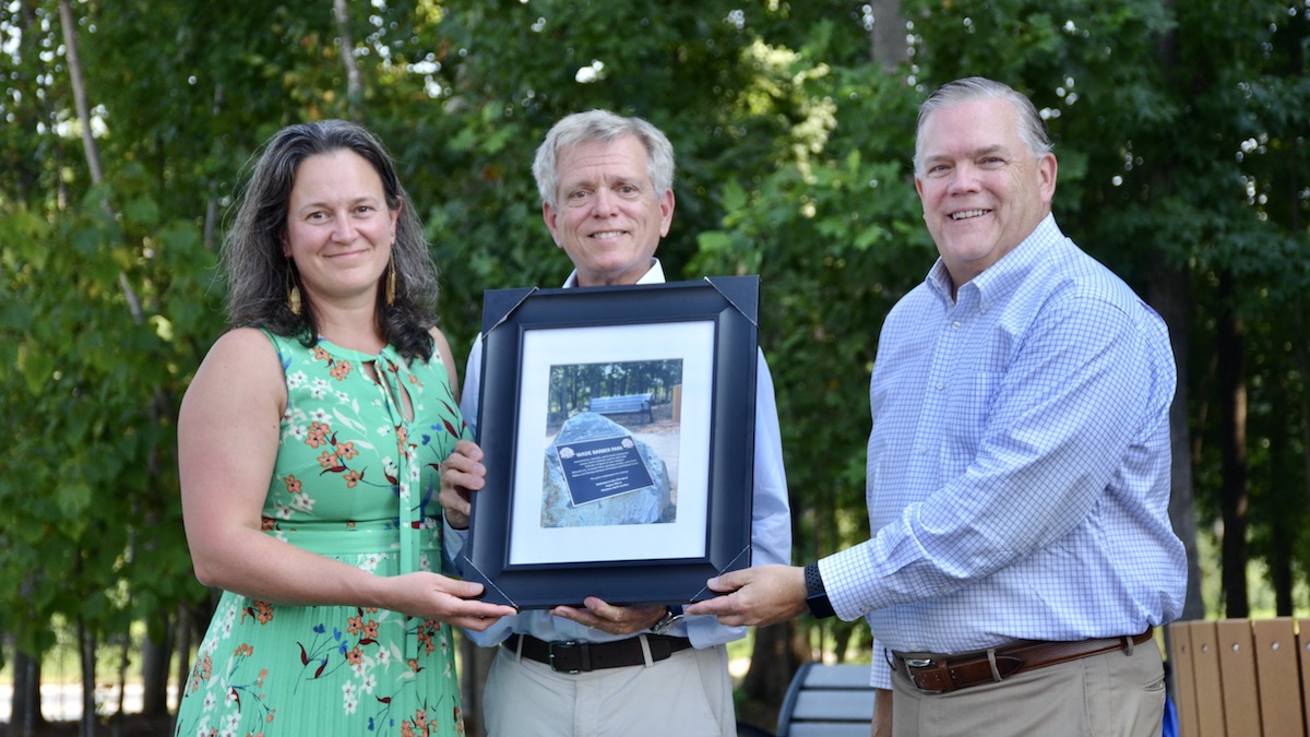 Wade Barber family members pose with plaque.